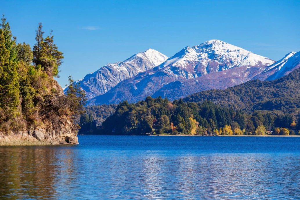 Paisagem de Bariloche mostrando o lago Nahuel Huapi, e uma floresta na saia da montanha Tronador com neve no topo.