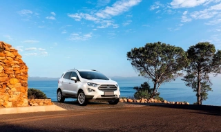 Ford EcoSport branco estacionado com o mar e o céu azul ao fundo.