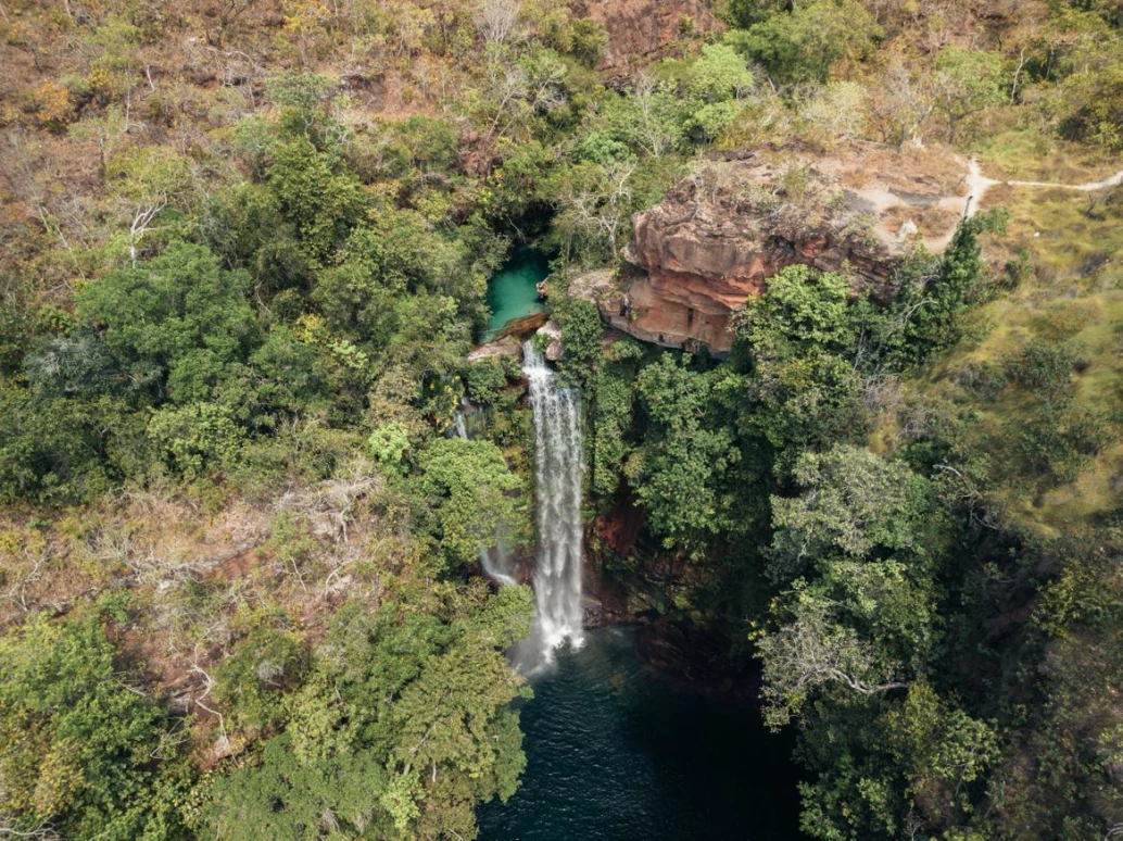 Vista aérea de uma queda d’água no meio de mata nativa em Barra do Garças, MT.
