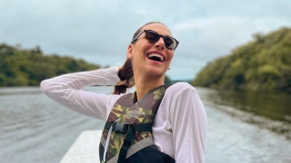 Mulher sorrindo à bordo de passeio de barco em rio