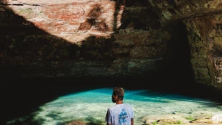 Homem admira a beleza de uma gruta na Chapada dos Guimarães