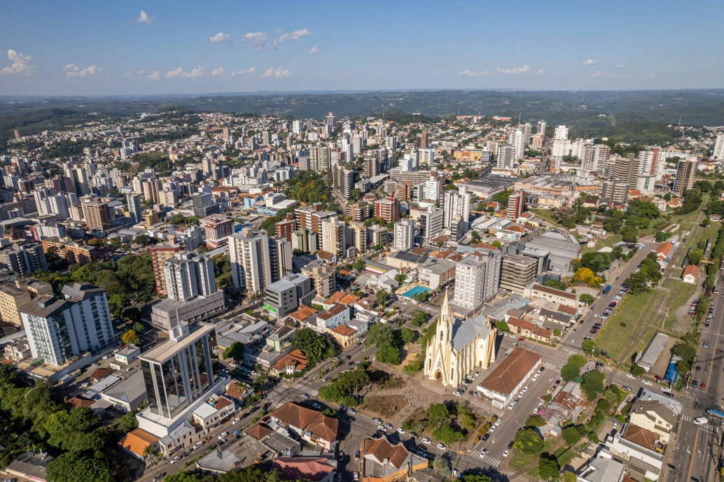 Vista aérea da região urbana de Bento Gonçalves. Entre edifícios modernos, destaca-se uma enorme igreja com arquitetura gótica