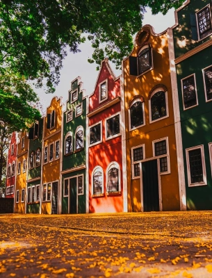 Várias casas com fachadas coloridas em dia claro.