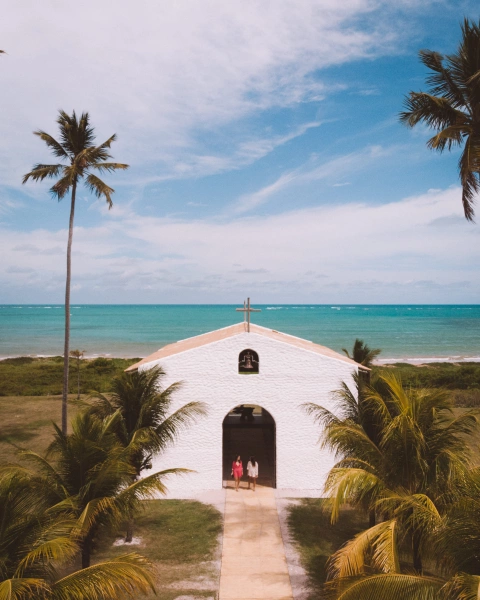 Foto de pequena capela à beira-mar em São Miguel dos Milagres. Alagoas, onde duas mulheres entram.