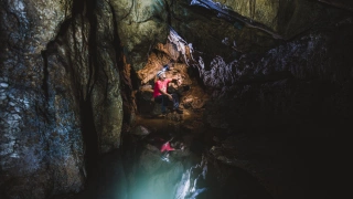 Vista interna de gruta com homem ao fundo apreciando a vista.