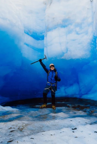 Homem com roupas de frio e equipamentos de trilha dentro de uma caverna de gelo na Patagônia chilena