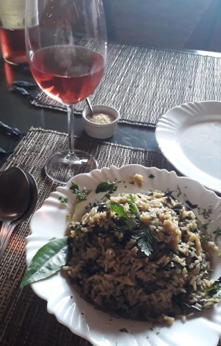 Foto de prato de risoto de ora-pro-nobis acompanhado de vinho rose