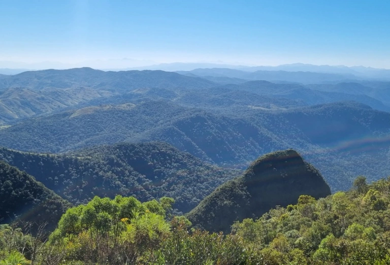 Vista panorâmica de montanhas cobertas por vegetação a partir de um mirante em Cunha - SP.