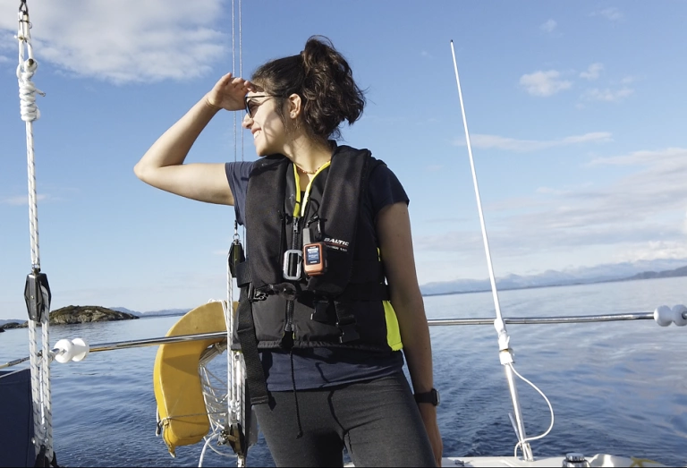 Navegadora Tamara Klink em pé dentro de veleiro em alto mar