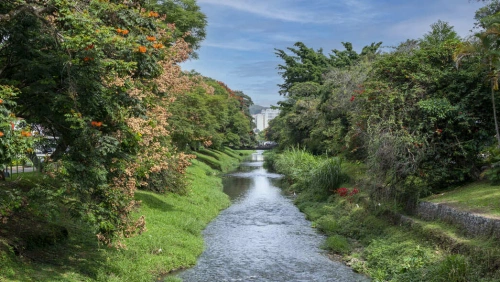 Extenso rio margeado por vegetação na cidade de Poços de Caldas.