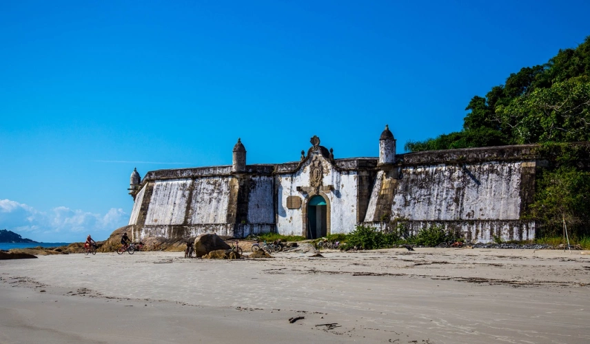 Fachada de uma construção antiga com aspecto envelhecido em frente ao mar