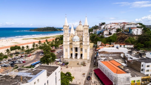 Vista aérea da cidade de Ilhéus, Bahia. Destaca-se uma igreja imponente no centro da imagem, e uma praia na margem esquerda
