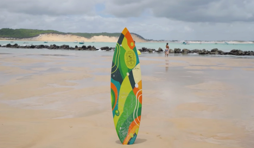 Prancha de surfe posicionada em praia em dia ensolarado