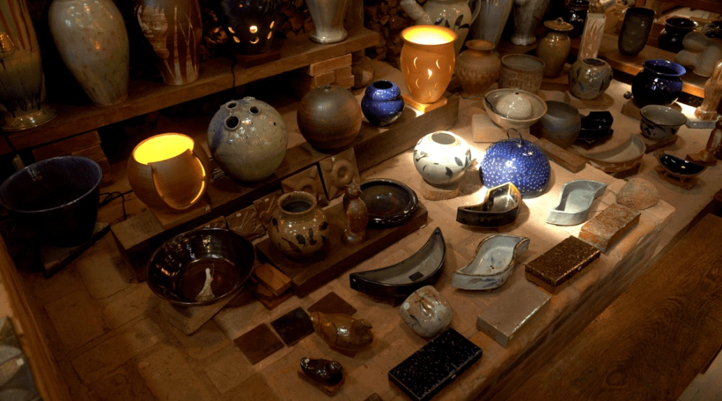 Diversos potes, vasos e recipientes de cerâmica agrupados em um piso marrom