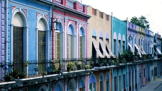 Vista lateral de prédios coloniais coloridos com algumas plantas nas sacadas