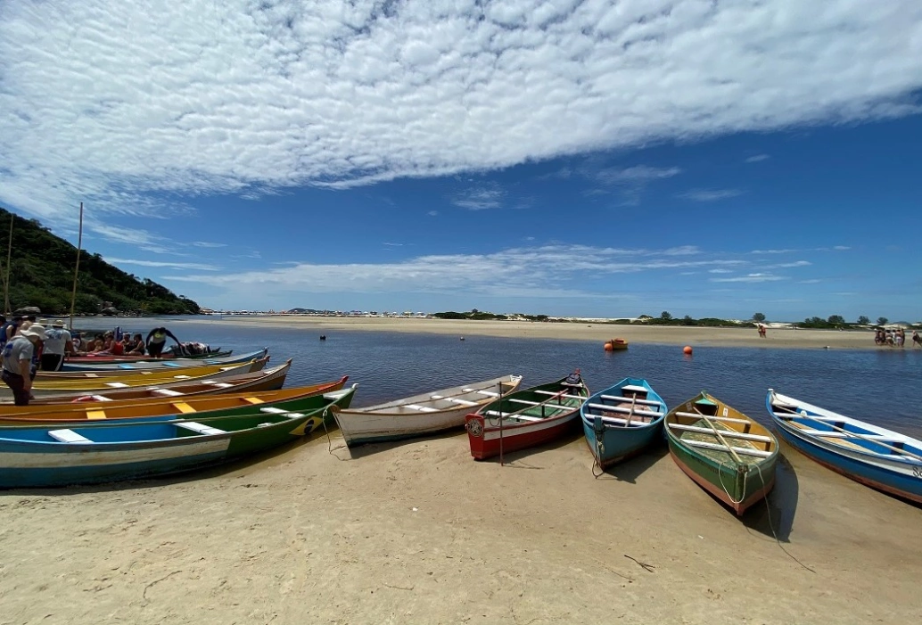 Vários barcos estacionados na beira da praia em Guarda do Embaú, SC.