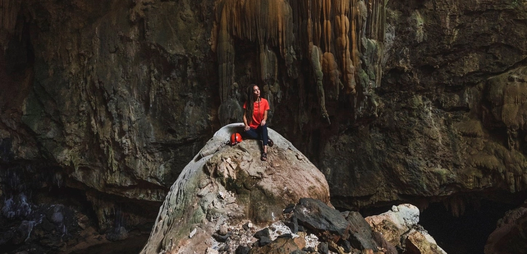 Influencer Cris Marques sentada em pedra da caverna de Terra Ronca em Goiás