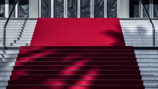 Fotografia em close da escadaria do Palais des Festivals, em Cannes, com tapete vermelho.