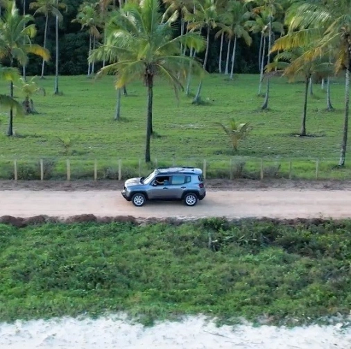 Um carro cinza modelo jeep renegade em uma estrada de terra