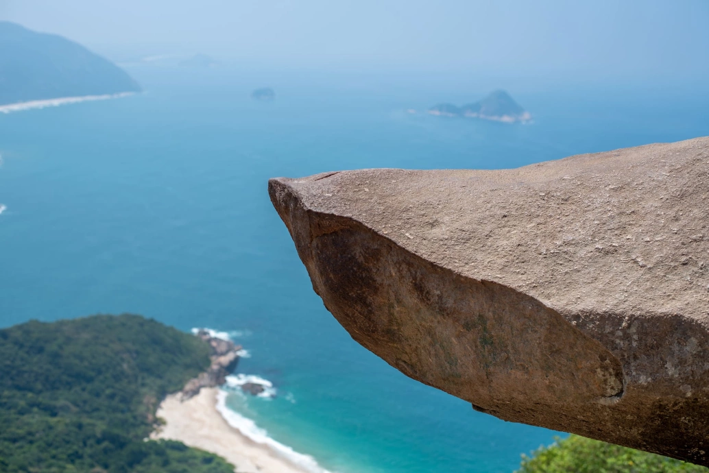 Ponta de uma pedra que fica a 354 metros de altura no Rio de Janeiro. O mar aparece ao fundo