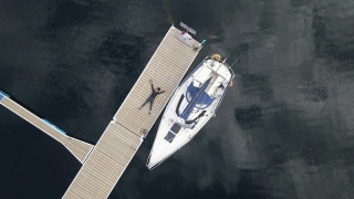 Tamara Klink deitada ao lado de veleiro estacionado em alto mar