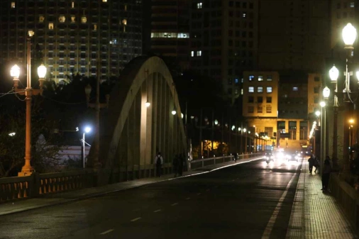 Carros passam por avenida urbana em noite belorizontina