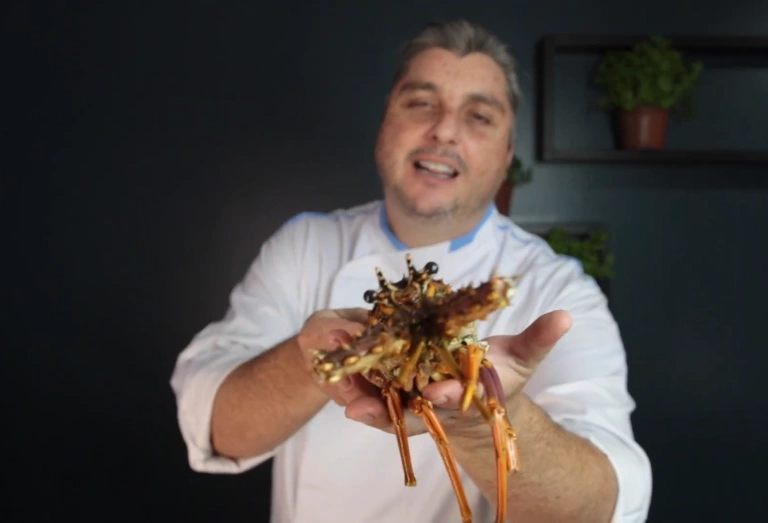 Chef de cozinha Serginho Jucá mostrando uma lagosta para a câmera