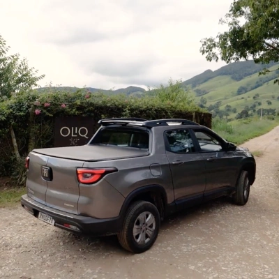 Carro de cor cinza do modelo Fiat Toro em região montanhosa de vegetação ativa