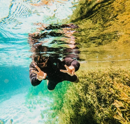 Homem posando em flutuação de rio de água cristalina