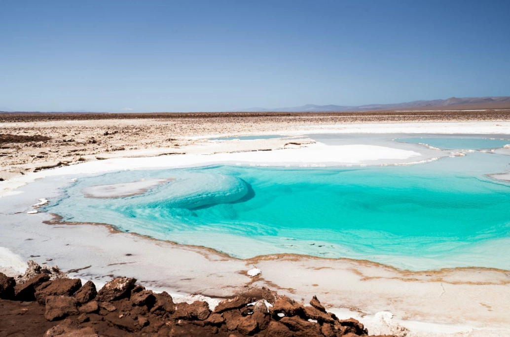 Lagoa cristalina em meio a deserto de sal.