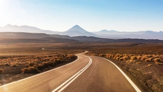 Estrada asfaltada, sinuosa e vazia em meio ao Deserto do Atacama