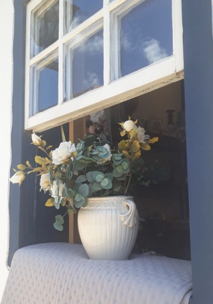 Um vaso de flores brancas em uma janela de casa colonial em Tiradentes