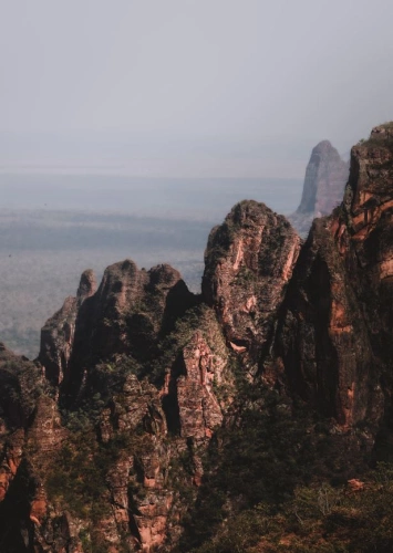Imponentes montanhas de pedra se destacam em meio à imagem semi-desertica na Chapada dos Guimarães
