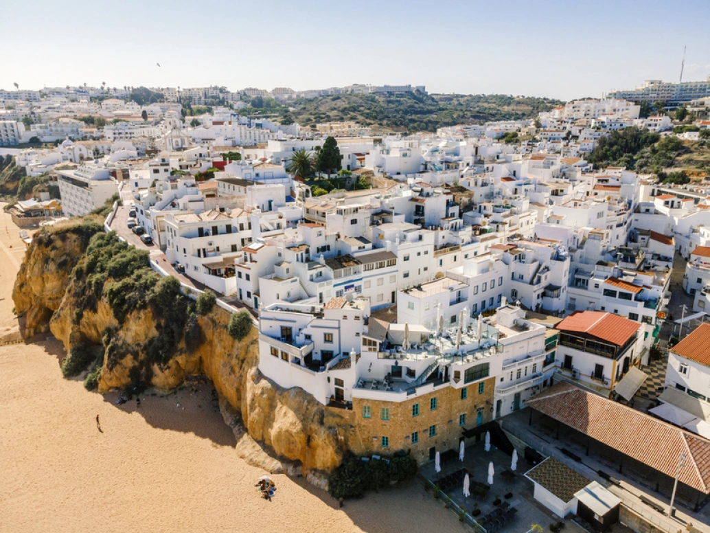Vista aérea de Albufeira, Algarve, Portugal. Casas brancas se estendem ao longo da costa da região.