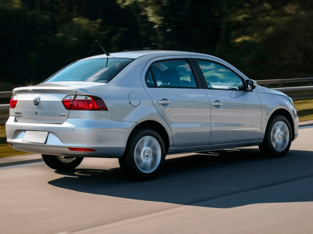 Volkswagen Voyage 1.6 2022 prateado em movimento em uma estrada com folhagens ao lado.