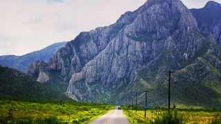 Vista de estrada que leva a imponente montanha que se levanta.