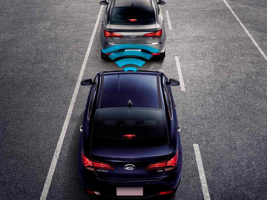 Dois carros Hyundai HB20S em uma estrada, um na frente do outro, com um símbolo azul entre eles indicando o alerta.