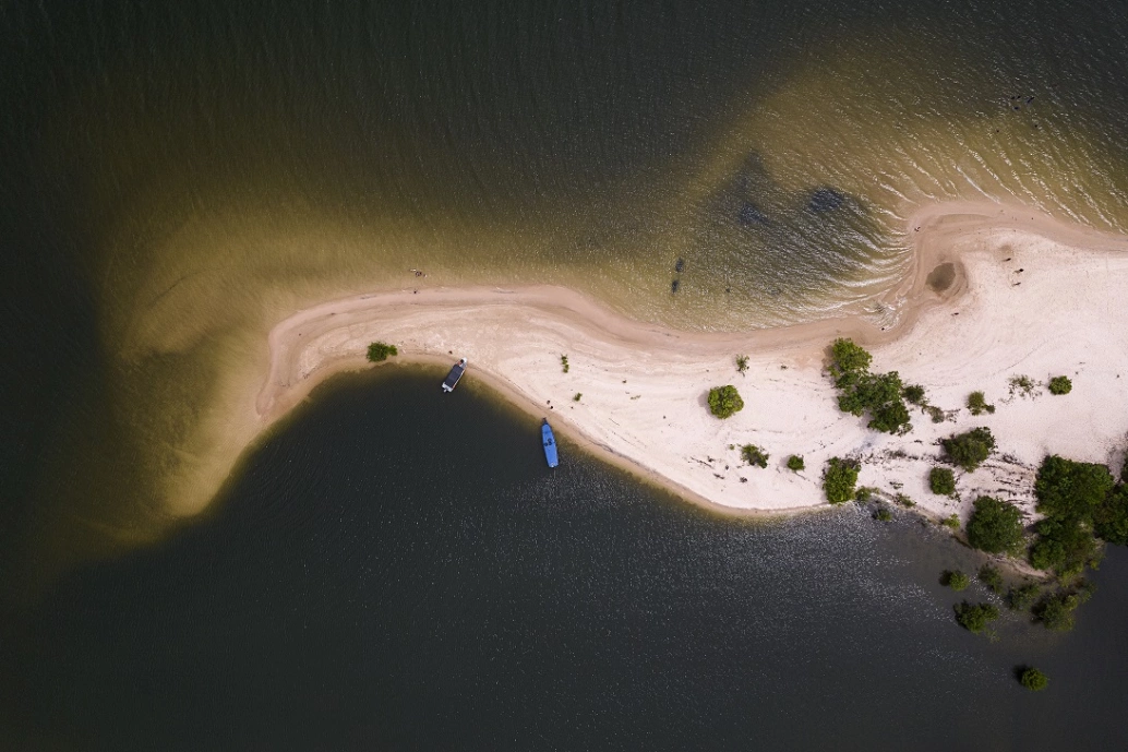 Vista de cima de ilha de água doce cercando areia branca em dia ensolarado