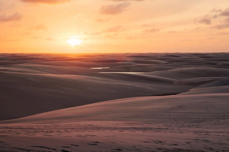 Pôr do sol destacando as ondulações formadas por diversas dunas de areia