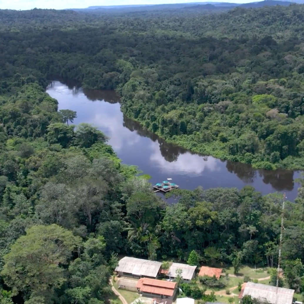 Imagem aérea da Floresta Amazônica, com o Rio Cristalino ao centro e as dependências do Lodge no canto inferior direito.
