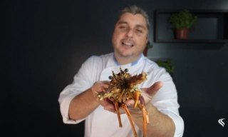Chef de cozinha Serginho Jucá mostrando uma lagosta para a câmera