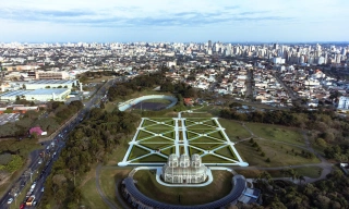 Vista aérea de Curitiba. No plano frontal, o Jardim Botânico com sua cúpula de vidro, que é cartão-postal da cidade