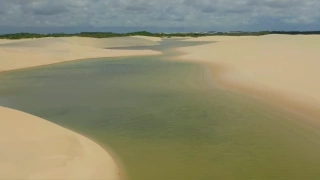 Lagoas de águas esverdeadas entre dunas de areia branca