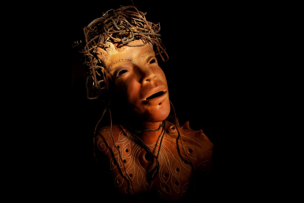 Fotografia de uma peça feita em cerâmica, representando um rosto humano.