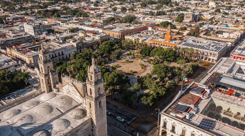 Grande praça cercada por prédios em cidade mexicana.