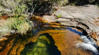 Piscina natural de água cristalina em meio à natureza pedrosa na Chapada dos Guimarães