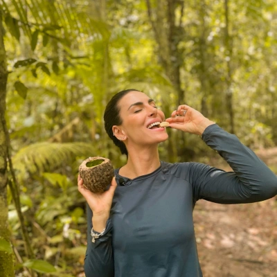 Mel Fronckowiak come fruta típica da Floresta Amazônica enquanto sorri